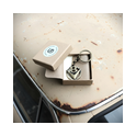 Runder V8 Schlüsselanhänger aus Messing in Geschenkbox auf beige Oldtimer‑Haube.