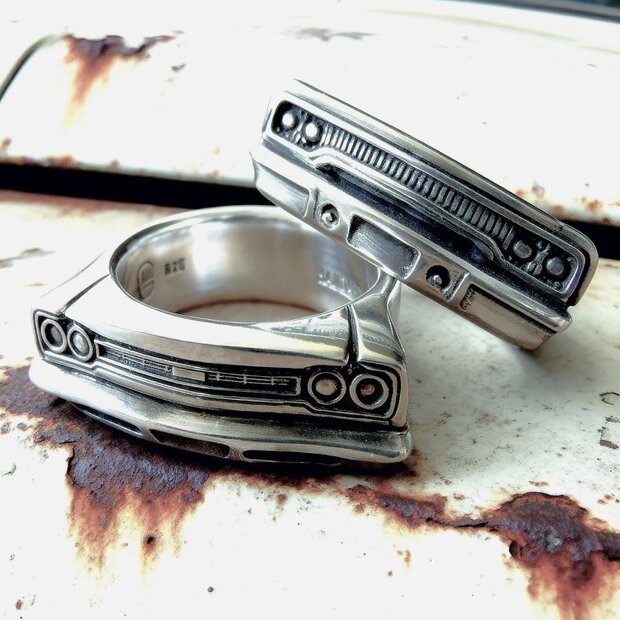 Auto Ringe in 925er Silber; Close-up auf altem Autolacklack.