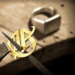Hand-cut gold monogram being prepared for a custom signet ring
