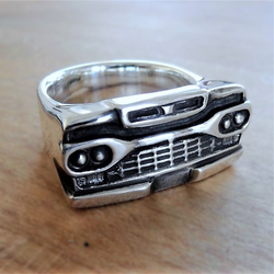 Ring mit der markanten Front eines Ford Pick-Up Trucks, aus glänzendem Metall, Nahansicht