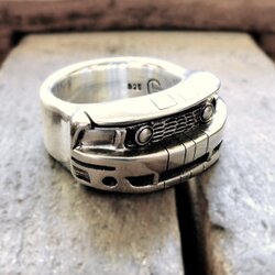 Ring mit der stilisierten Front eines Kustom Ford Mustang, chromfarben und detailreich, auf dunklem Hintergrund