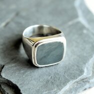 Handgefertigter schlichter Herrenring aus 925 Sterling Silber mit rechteckiger Siegelplatte auf grauem Schieferstein