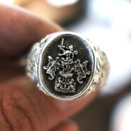 Silberner Wappenring mit fein graviertem Löwenwappen, geschwärzter Siegelplatte und ornamentierter Ringschiene in Nahaufnahme