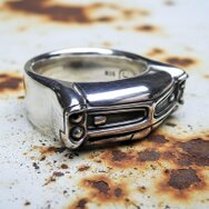 Massiver Silberring mit detailreicher US Car Front, Oldtimer Design und polierter Karosserieform auf rostigem Metalluntergrund