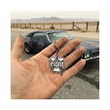 Silberner V8 Schlüsselanhänger in der Hand vor klassischem US-Car – robustes Accessoire für Muscle-Car & Oldtimer Liebhaber